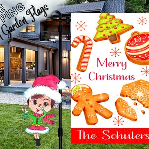 May include: A white Christmas-themed garden flag with a gingerbread man, candy cane, Christmas tree, and ornament cookies. The text "Merry Christmas" and "The Schulers" are printed on the flag.