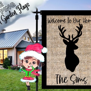 May include: A burlap garden flag with a black silhouette of a deer head and the text "Welcome to Our Home The Sims".