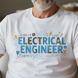 May include: White t-shirt with the words "ELECTRICAL ENGINEER" in blue and gold, along with electrical symbols. The shirt has a crew neck and short sleeves. The design includes equations and circuit board patterns.