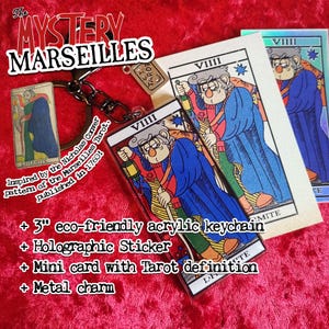 May include: A 3-inch eco-friendly acrylic keychain featuring the Strength card from a Mystery Marseilles Tarot deck. The keychain comes with a holographic sticker, a mini card with the Tarot definition, and a metal charm.