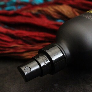 May include: A black spray bottle with a black nozzle and a label that reads "ROW RELIE", with a red and orange background.