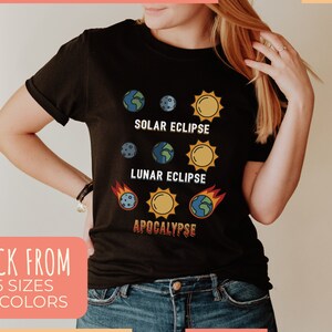 May include: Black t-shirt featuring a graphic design of a solar eclipse, lunar eclipse, and the word "apocalypse".