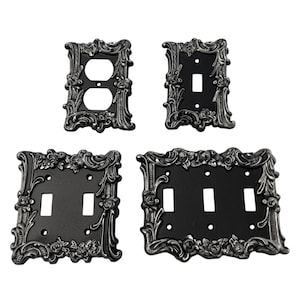 以下が含まれることがあります： 黒の仕上げに装飾的な銀色の花のデザインが施された、装飾的な壁用プレートスイッチカバー4個セット。プレートには、シングルスイッチ、ダブルスイッチ、トリプルスイッチが含まれています。