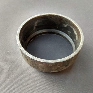 May include: A metal ring with a slightly worn surface. The ring is a simple, circular shape with a smooth, rounded edge.