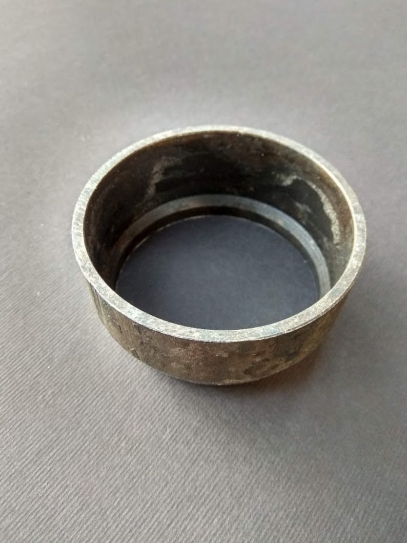 May include: A metal ring with a slightly worn surface. The ring is a simple, circular shape with a smooth, rounded edge.