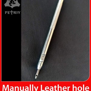 Puede incluir: Una herramienta de punzonado de cuero plateada con un mango texturizado. La herramienta está marcada con el número "1.5".