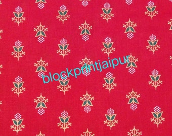 Puede incluir: Tela roja con un patrón repetido de pequeños diseños florales dorados. El texto "blockprintjaipur" está impreso en azul en la tela.