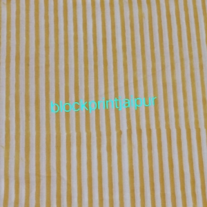 May include: A close-up of a yellow and white striped fabric with the text "blockprintjaipur" in turquoise.