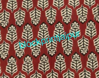 May include: Red fabric with a repeating pattern of black and white leaf designs. The text "blockprintjaipur" is printed in blue across the fabric.