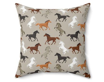May include: A beige throw pillow with a repeating pattern of brown, black, white, and orange horses running in different directions.