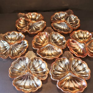 Puede incluir: Juego de seis platos de servir vintage de vidrio naranja iridiscente. Cada plato tiene forma de trébol de tres hojas con bordes festoneados.