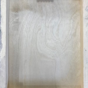 K&ouml;nnte beinhalten: Die R&uuml;ckseite eines Holzbildrahmens mit einem daran befestigten Metall-Aufh&auml;nger oben. Der Rahmen ist aus hellem Holz und hat eine nat&uuml;rliche Oberfl&auml;che.