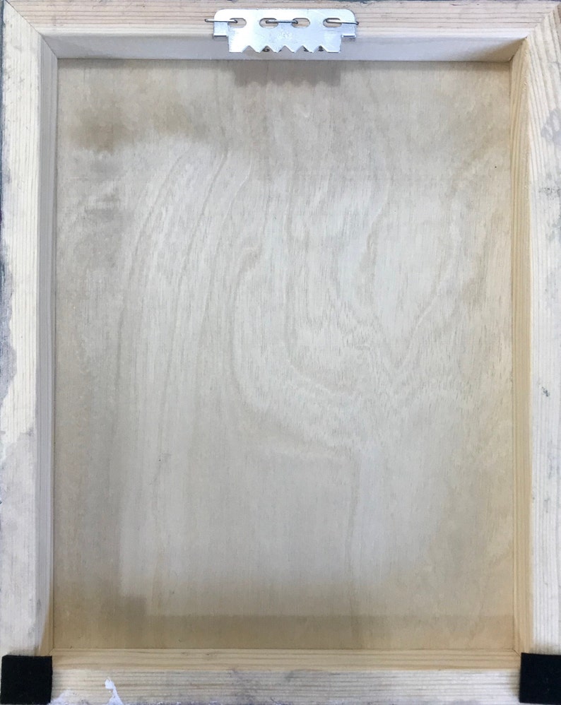 K&ouml;nnte beinhalten: Die R&uuml;ckseite eines Holzbildrahmens mit einem daran befestigten Metall-Aufh&auml;nger oben. Der Rahmen ist aus hellem Holz und hat eine nat&uuml;rliche Oberfl&auml;che.