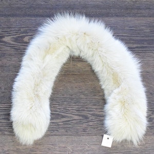 May include: A white fur collar for a coat or jacket. The collar is made of soft, fluffy fur and is in a U-shape.
