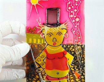 May include: A yellow cartoon character with a pink top hat, red top, and yellow legs stands on a brown and yellow background. The character has a pink nose and a belly button. The background is pink with a yellow sun and white lines.