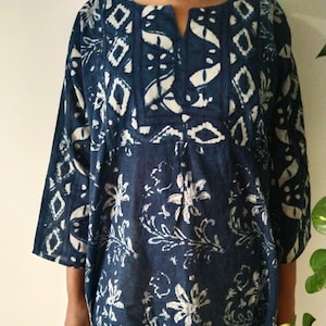 May include: A blue and white cotton tunic with a floral print. The tunic has a V-neck and three-quarter sleeves.