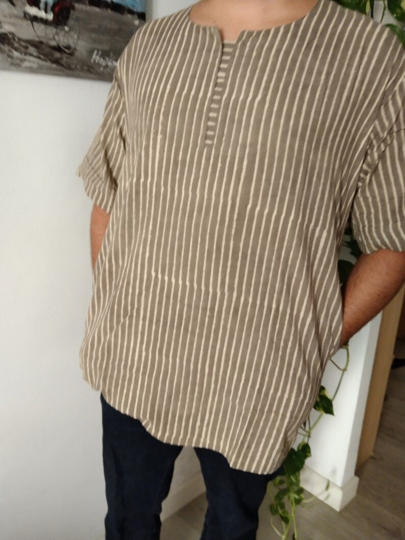 May include: A brown and white striped shirt with a short sleeve and a button-up collar.