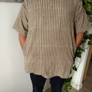 May include: A brown and white striped short-sleeved shirt with a button-up collar.