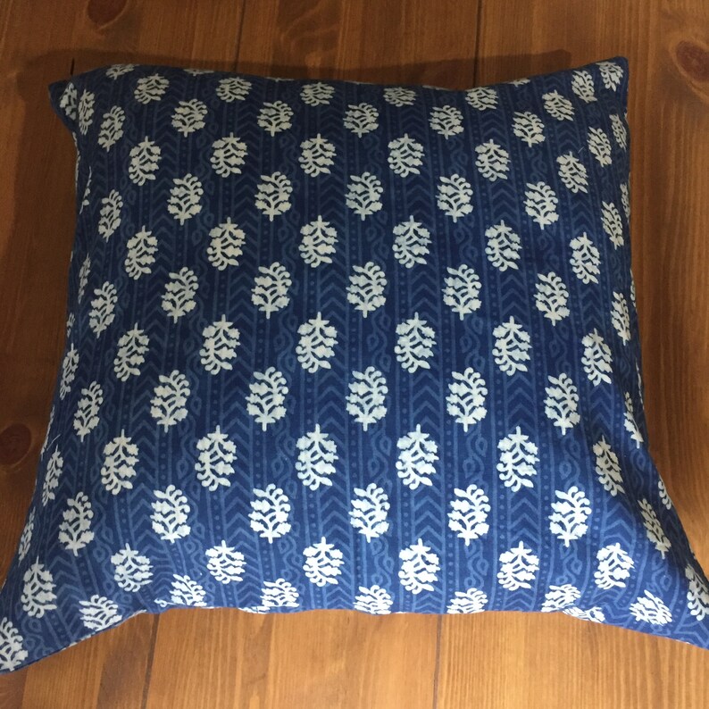 May include: A blue and white patterned throw pillow with a floral design. The pillow is made of a soft, comfortable fabric and is perfect for adding a touch of style to any room.