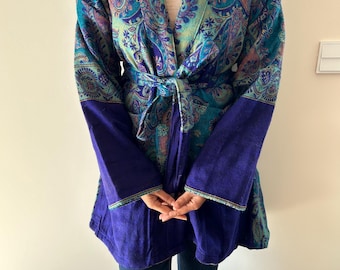Puede incluir: Bata tipo kimono estampada en verde azulado, morado y azul, con mangas largas y cinturón anudado. Las mangas y la parte inferior de la bata son de color morado intenso liso. La bata presenta un diseño de cachemira.