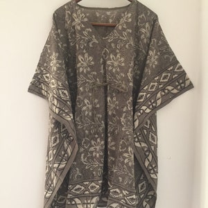 May include: A brown and white patterned kaftan with a V-neck and a tie at the waist.
