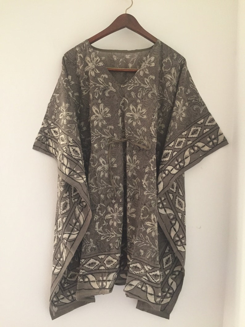 May include: A brown and white patterned kaftan with a V-neck and a tie at the waist.