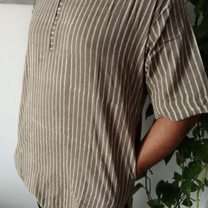 May include: A brown and white striped short-sleeved shirt with a button-up collar.