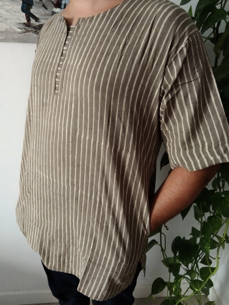 May include: A brown and white striped short-sleeved shirt with a button-up collar.
