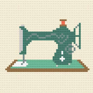 Könnte beinhalten: Ein Kreuzstichmuster im Pixel-Art-Stil einer dunkelgrünen Nähmaschine. Die Maschine verfügt über eine hellgrüne Basis, eine kleine orangefarbene Spule oben, einen weißen Nadelbereich und ein weißes Pluszeichen an der Seite, alles vor einem cremefarbenen Hintergrund.