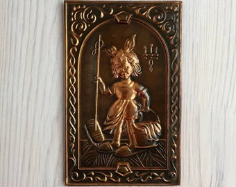 May include: A copper wall plaque with an embossed image of a girl holding a broom and a bucket. The plaque has a dark brown background and a decorative border.