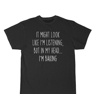 K&ouml;nnte beinhalten: Schwarzes T-Shirt mit wei&szlig;em Text, der lautet: "Es mag aussehen, als w&uuml;rde ich zuh&ouml;ren, aber in meinem Kopf... backe ich."