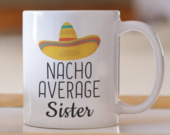 May include: White ceramic mug with a black and yellow graphic of a sombrero and the text "Nacho Average Sister".