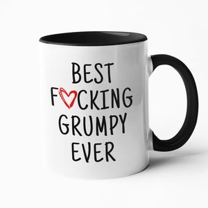 May include: White ceramic coffee mug with a black rim and handle. The mug has black text that reads "Best F♡cking Grumpy Ever".