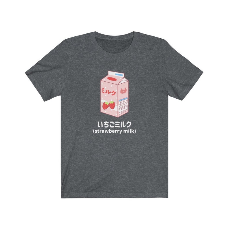 May include: A dark heather grey t-shirt with a cartoon illustration of a pink carton of strawberry milk. The carton has the Japanese word "ミルク" (milk) and the text "いちごミルク (strawberry milk)".