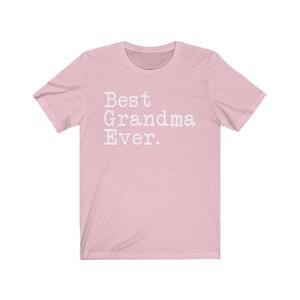 Puede incluir: Camiseta rosa de manga corta con el texto "Best Grandma Ever." en blanco.