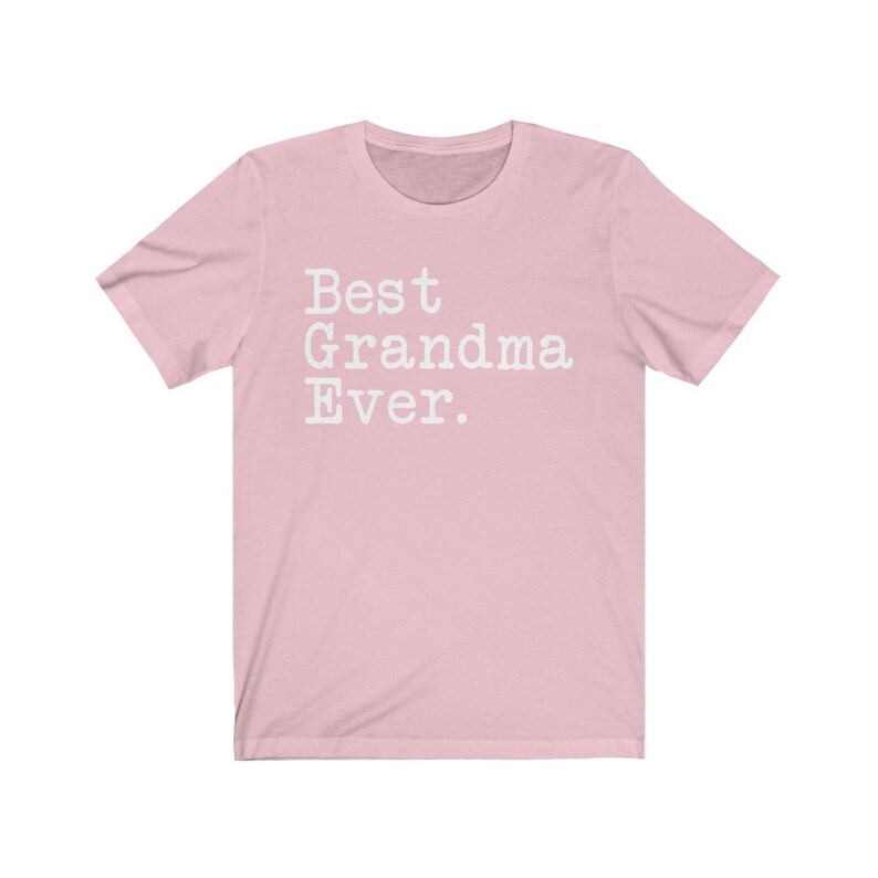 Puede incluir: Camiseta rosa de manga corta con el texto "Best Grandma Ever." en blanco.
