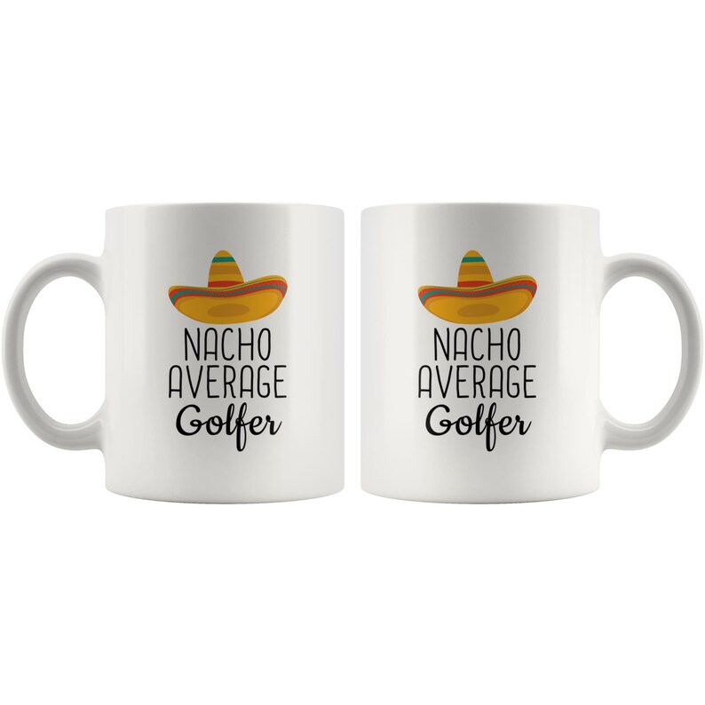 May include: Two white ceramic coffee mugs with black text that reads "Nacho Average Golfer" and a cartoon sombrero on each mug.