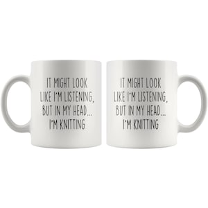 May include: Two white ceramic mugs with black text that reads "It might look like I'm listening, but in my head... I'm knitting".