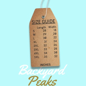May include: A brown paper size guide tag with the text "SIZE GUIDE" and a chart listing sizes S through 5XL with corresponding length and width measurements in inches. The tag is labeled "Backyard Peaks" in gold lettering.