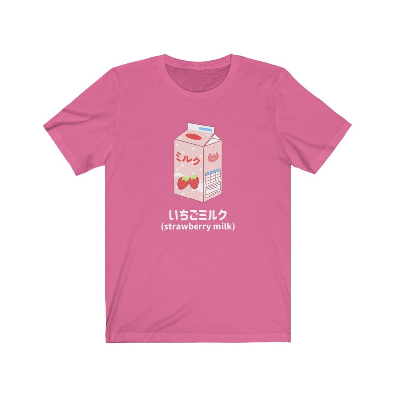 May include: Pink t-shirt with a cartoon illustration of a carton of strawberry milk. The carton is labeled "ミルク" (milk) and "いちごミルク" (strawberry milk).