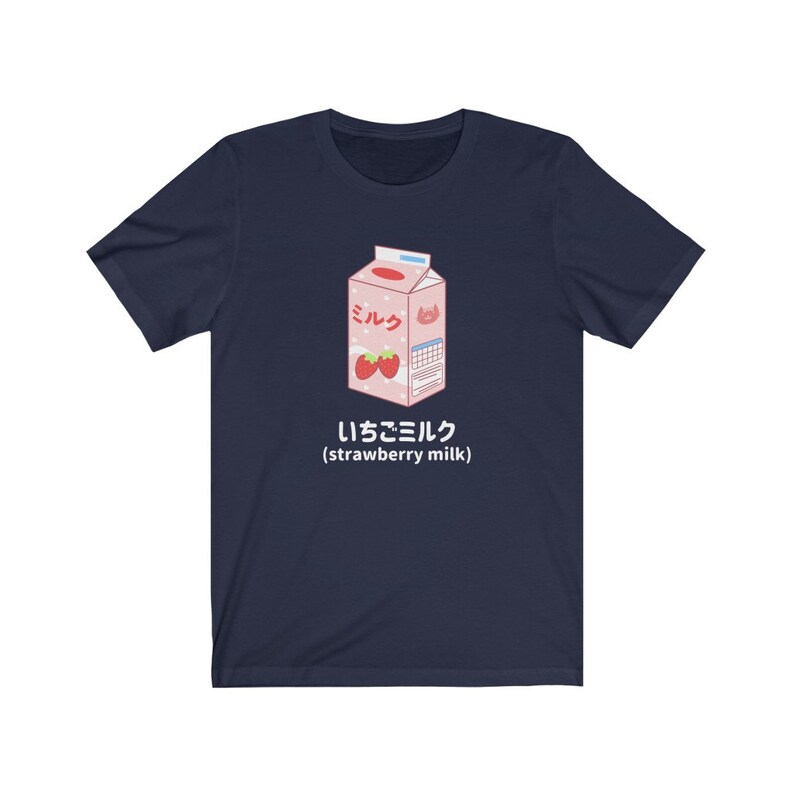 May include: A navy blue t-shirt with a cartoon illustration of a pink carton of strawberry milk. The carton has the Japanese word "ミルク" (milk) and the text "いちごミルク (strawberry milk)".