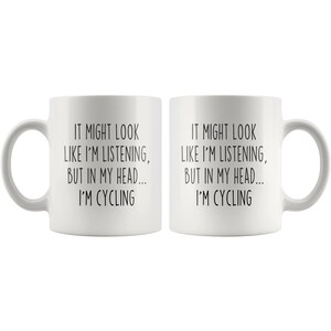 May include: White ceramic coffee mug with a black text design that reads "It might look like I'm listening, but in my head... I'm cycling."