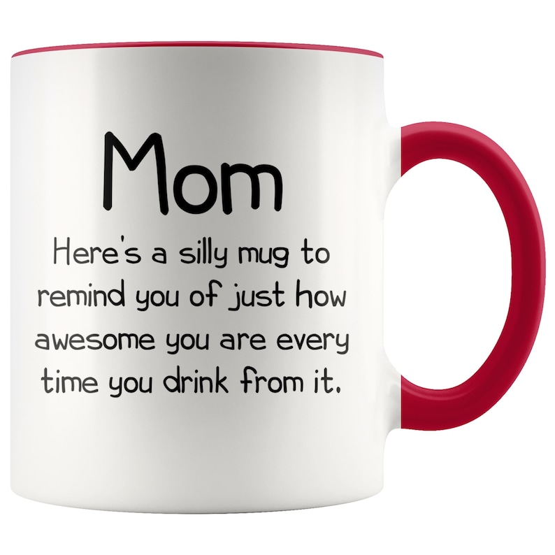 May include: White ceramic coffee mug with a red rim and handle. The mug has black text that reads "Mom Here's a silly mug to remind you of just how awesome you are every time you drink from it."