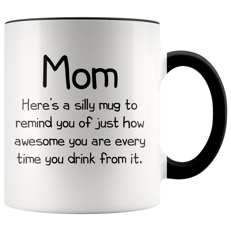 May include: White ceramic coffee mug with a black rim and handle. The mug has black text that reads "Mom Here's a silly mug to remind you of just how awesome you are every time you drink from it."