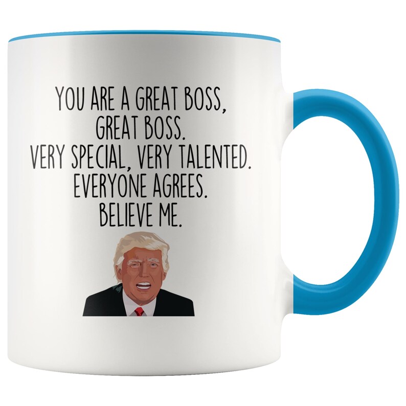 May include: White ceramic coffee mug with a blue rim and handle. The mug features a black and white illustration of Donald Trump and the text "You are a great boss, great boss. Very special, very talented. Everyone agrees. Believe me."