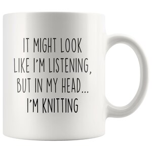 May include: White ceramic mug with black text that reads "It might look like I'm listening, but in my head... I'm knitting".