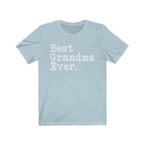 Puede incluir: Una camiseta azul claro con el texto "Best Grandma Ever." impreso en blanco.