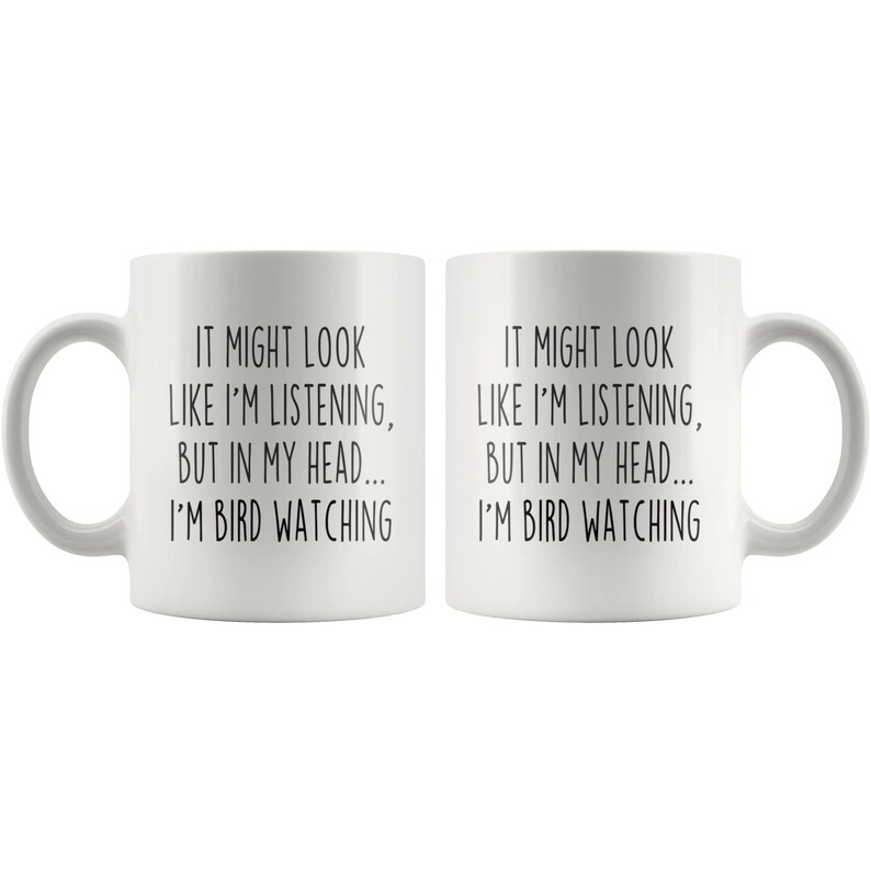 Puede incluir: Dos tazas de caf&eacute; blancas con texto negro que dice "It might look like I'm listening, but in my head... I'm bird watching".