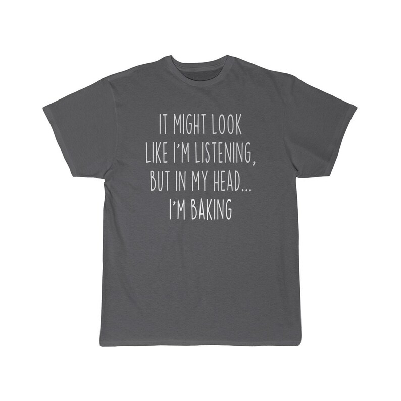 K&ouml;nnte beinhalten: Dunkelgraues T-Shirt mit wei&szlig;em Text, der lautet "It might look like I'm listening, but in my head... I'm baking."