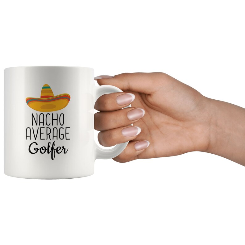 May include: White ceramic coffee mug with a black and yellow sombrero graphic and the text "Nacho Average Golfer".